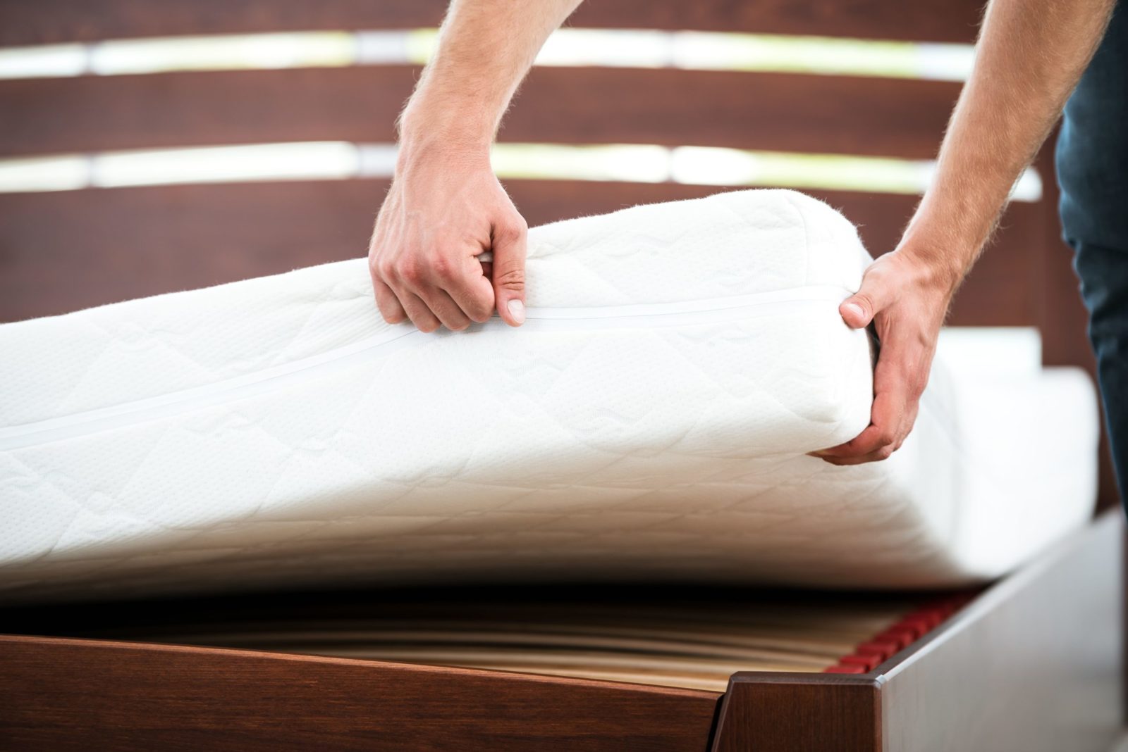 A junk removal expert hauling a mattress away